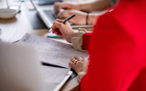 Desk with people writing
